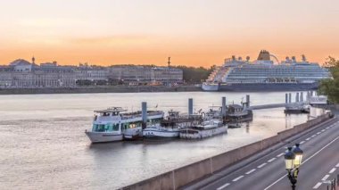 Gemi ve tekneler Fransa 'nın Bordeaux kentindeki Garonne Nehri boyunca iskeleye yanaştı. Günbegün deniz manzaralı geçiş zamanları, caddelerde trafik ve tarihi mimari
