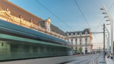 Fransa 'nın Aquitaine kentindeki ana demiryolu merkezi olan Bordeaux Saint Jean Tren İstasyonu, saatli büyük bir girişe sahiptir. Günbatımında tramvaylar geçer, tarihi cephede gölgeler hareket eder.