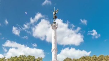 Bordeaux, Fransa 'da Esplanade Des Quinconces zaman ayarlı fıskiyeli Aux Girondins Anıtı. Tarihi eser ve mimari şaheser özgürlüğü ve devrimi simgeliyor. Mavi bulutlu gökyüzü