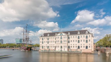 Denizcilik Müzesi 'nin hiperlapse' si ve Amsterdam 'ın deniz kenarı kopyası. Bulutlu mavi gökyüzü. Kültürel aktiviteleri, kanalları ve köprüleri meşhurdur. Amsterdam, Hollanda
