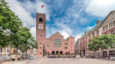 Beursplein 'in tarihi Beurs van Berlage binası, eski bir emtia borsası, şimdi de konserler ve sergiler için bir mekan. Meydanda yürüyen insanlar. Amsterdam, Hollanda