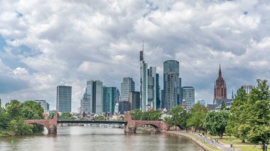 Frankfurt 'un gökdelenlerinin yükselişi Saint Bartholomew İmparatorluk Katedrali' nin çan kulesinin ana nehir üzerindeki tarihi taş köprü Alte Brucke 'ye bakışıyla gerçekleşiyor. Frankfurt, Almanya