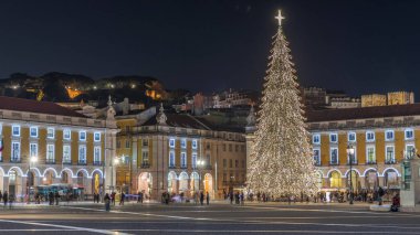 Lizbon 'daki ticaret meydanı, Noel' in aşırı hızıyla aydınlandı. Yükselen bir ağaç ve geceleri kutlayan kalabalıkla. Bir tepenin üzerindeki şenlikli atmosfer dekorasyonları ve tarihi mimarinin zamanı.