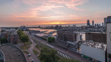 Rotterdam 'daki Katendrecht ve Maas Nehri gibi demirli gemilerle Maashaven' daki hava panoramik görüntüsü günden geceye geçiş zamanı. Eski fabrika yakınlarındaki trafik ofis ve etkinlik alanına dönüştü