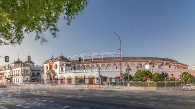 Plaza de Toros de la Real Maestranza de Caballeria de Sevilla zaman atlaması. İspanya 'nın Seville şehrinde boğa güreşi festivalleriyle tanınan tarihi boğa güreşi. Trafik ön cephesinin önünden geçiyor.