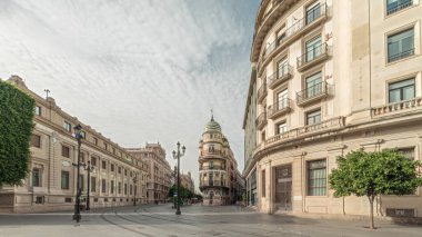 Avda boyunca yürüyen yayalar. De la Constitucion, Seville, İspanya 'nın Casco Antiguo bölgesindeki ana cadde. Edificio de la Adriatica ile zaman atlaması, tarihi binalar ve geçen tramvaylar