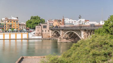Puente de Isabel Köprüsü, Guadalquivir Nehri üzerinden Sevilla 'yı Triana ilçesine bağlayan Guadalquivir Nehri boyunca uzanır. Capilla del Carmen Kilisesi ve binalar suyu yansıtıyor.