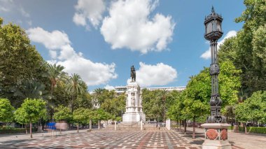 Seville 'deki Plaza Nueva' da, yeşil ağaçlar ve tarihi binalarla çevrili Kral San Fernando 'nun binicilik heykeli yer alıyor. Mavi gökyüzünün altında manzaralı bir şehir alanı