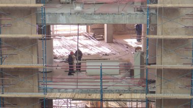 Construction equipment material with scaffolding and tools inside the floor of multi-level building timelapse, skyscraper. Building under construction. Interior work in progress.