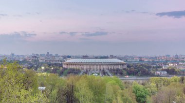 Moskova City, Rusya 'nın panoramik manzarası, gün batımından sonra Sparrow Hills' ten gece geçiş zamanına kadar. Luzhniki Stadyumu ve nehir üzerindeki köprü