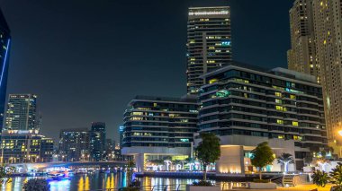 Dubai Marina, yatları ve briç gecesi hiperhızlandırılmış restoranları olan modern kuleleri olan, Birleşik Arap Emirlikleri ile dolanıyor. Gökdelenlerde parlayan pencereler