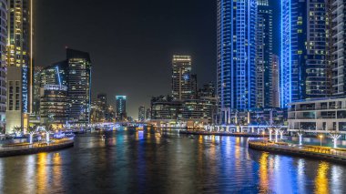 Dubai Marina 'da yatları ve Dubai' deki köprüden restoranları olan modern kuleleri olan bir gezinti alanı, Birleşik Arap Emirlikleri. Yapay kanalla aydınlatılmış bölge