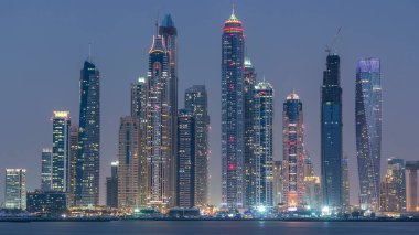 Dubai Marina ufuk çizgisi günden geceye geçiş zamanı panorama Palm Jumeirah, Dubai, BAE 'den görüldüğü gibi. Dubai 'nin bu kısmında 50 kattan fazla gökdelen var.