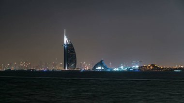 Dubai 'nin gece silueti, Burç al Arab ile birlikte Dubai, Birleşik Arap Emirlikleri' nde. Palm Jumeirah 'dan görüntü