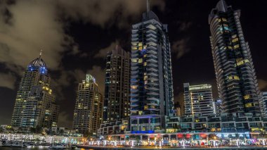 Dubai Marina gezinti güvertesinde yatlar ve modern kuleler ile Dubai 'deki deniz kıyısından yansıyan su, Birleşik Arap Emirlikleri. Dubai Marina, Dubai 'de bir şehirdir..
