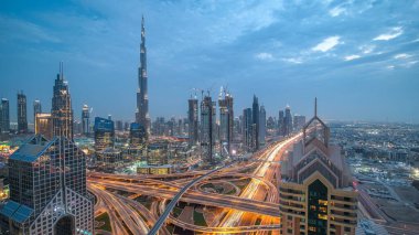 Modern gökdelenler ve yoğun gece otoyolları Dubai şehir merkezindeki lüks geçiş zamanlarında. Kule çatısından üst hava manzarası. Yol kavşağı trafiği. Dubai, Birleşik Arap Emirlikleri