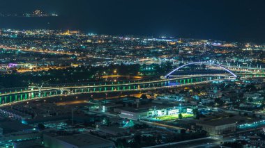 Dubai su kanalı zaman ayarlı ve gece boyunca teknelerin geçtiği ışıklı köprüler var. Kule çatısından gökyüzü görüntüsü. Deniz kıyısındaki ışıklardan gelen suya yansıyan yansıma