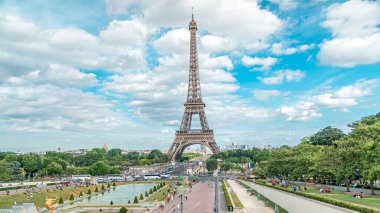 Trocadero Meydanı 'ndaki fıskiyeler ve arka planda Eyfel Kulesi. Trocadero ve Eyfel Kulesi Paris 'in en çok ziyaret edilen yerleridir. Yaz günü bulutlu bir gökyüzü. Yol ayrımında trafik