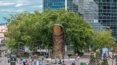 İşletme Bölgesi Savunması 'nda başparmak heykeli zamanı ve kule bloğu. Yukarıdan bak, insanlar bankta oturuyor.