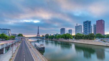 Eyfel Kulesi Seine Nehri 'nde ve Fransa' nın Paris şehrinde teknelerle renkli gündoğumu zamanı. Grenelle Köprüsü 'nden hava görüntüsü. Modern binalar ve yol trafiği. Dramatik bulutlar