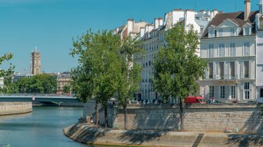 Saint-Louis Köprüsü 'nün zaman çizelgesi ve Orleans rıhtımındaki evler. Paris, Fransa 'da Seine nehrinde Ile de la Cite ve Ile Saint Louis adında iki ada. Arka planda bir kule. Paris, Fransa.