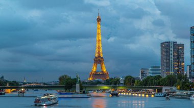Eyfel Kulesi ve Özgürlük Anıtı modern binalarla birlikte gece gündüz su geçiş zamanlarını yansıtıyordu. Gün batımından sonra Mirabeau Köprüsü 'nden görüntü. Paris, Fransa