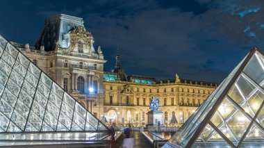 Louvre Piramidi ile ünlü Louvre Müzesi gece vakti ışık saçar. Dolunay. Arka planda 14. Louis heykeli. Paris, Fransa