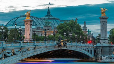 Paris 'teki Alexandre Köprüsü gece gündüz aydınlandı geçiş zamanı. Gün batımından sonra Grand Palais 'de. Trafik sıkışık. Paris, Fransa