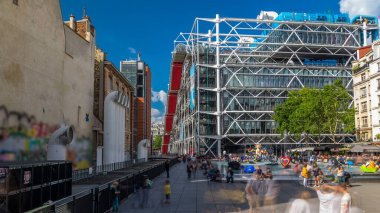Centre Pompidou zaman ayarlı hiperhızlandırılmış çeşme, Ulusal Modern Sanat Müzesi. Paris, Fransa. İnsanlar yaz günü mavi bulutlu gökyüzü ile meydanda oturup dinleniyorlar.