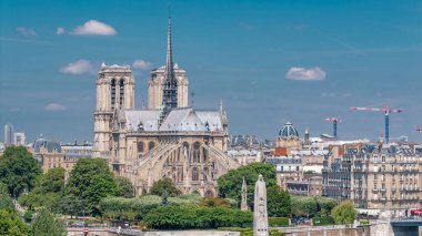 Paris, Cite Adası ve Katedral Notre Dame de Paris ile birlikte Arap Dünya Enstitüsü gözlem güvertesinin arka planında. Üst Manzara. Yeşil ağaçlar, yaz gününde mavi bulutlu gökyüzü. Fransa.
