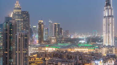 Dubai Şehir Merkezi 'nden geceye geçiş zamanı. Geceleri büyük, fütüristik şehir üzerinde hava manzarası. Dubai ve AVM 'nin gökdelenleri, Birleşik Arap Emirlikleri. Akşam gökyüzü çatıdan yükseliyor