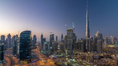 Dubai Şehir Merkezi 'nden geceye geçiş zamanı. Gece vakti büyük, fütüristik şehir üzerinde hava manzarası. Dubai 'nin gökdelenleri, Birleşik Arap Emirlikleri. Akşam gökyüzü çatıdan yükseliyor