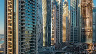 Modern gökdelenler ile Yatlar Dubai, Birleşik Arap Emirlikleri Dubai Marina günbatımı ışıklar timelapse parlayan bir bakış. Camına yansıyan ışık ışınları.