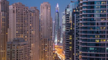 Dubai Yat Limanı ve Jbr gün gece geçiş hava timelapse, Birleşik Arap Emirlikleri için aydınlatma akşam. Modern gökdelenler ve binalar. Yolda trafik