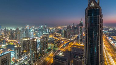 Gün gece geçiş timelapse modern için Dubai Downtown Dubai, Suudi Arabistan, üstten panoramik görünüm kuleleri. Business bay yakınındaki Şeyh Zayed Yolu üzerinde trafik