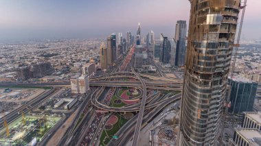 Dubai şehir merkezindeki ufuk çizgisi günden geceye geçiş zamanı. Şeyh Zayed kavşağındaki çok sayıda aydınlatma kulesiyle çatıdaki trafiğin görüntüsü.