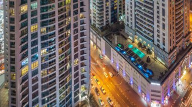 Parlayan ve windows en yüksek gökdelenler, Bütün gece timelapse sırasında yanıp sönüyor. Dubai Yat Limanı modern konut yüksek katlı binaların görünümü. Daire içinde hareket insanlar. Hava üstten görünüm.