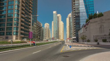 Dubai Yat Limanı gökdelenler timelapse hyperlapse ve beton yolu Köprüsü kanal aracılığıyla sokakta trafik ile. Mavi gökyüzü güneşli gün. Dubai, Birleşik Arap Emirlikleri.