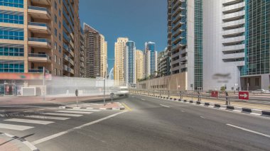 Dubai Yat Limanı gökdelenler timelapse hyperlapse ve beton yolu köprüsü tramvay rayları ile kanal aracılığıyla sokakta trafik ile. Mavi gökyüzü güneşli gün. Dubai, Birleşik Arap Emirlikleri.