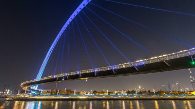 Fütüristik Dubai su kanal ışıklı gece timelapse hyperlapse, Birleşik Arap Emirlikleri, üzerinde yaya köprüsü. Cityscape arka plan üzerinde. Promenade görüntülemek