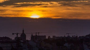 Lizbon, gün batımında şehir merkezinin havadan görüntüsü. Sonbahar akşamı Portekiz 'de turuncu gökyüzü. Miradouro da Nossa Senhora do Monte bakış açısından üstten görünüm