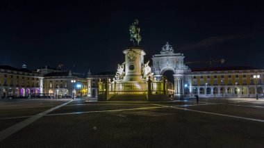 Triumphal arch at Rua Augusta and illuminated bronze statue of King Jose I at Commerce square lited at night timelapse hyperlapse in Lisbon, Portugal.
