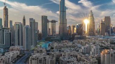 Gün batımında Dubai şehir merkezi silueti Burj Halife ve diğer panoramik manzaralı Dubai, Birleşik Arap Emirlikleri. Geleneksel ve modern binalar. Çember yollarda ve çeşmelerde trafik