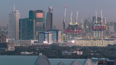 Dubai şehir merkezi mimarisi ile Aerial cityscape ve günlük geçiş timelapse, Birleşik Arap Emirlikleri finans merkezi gece. Şantiye ile en yüksek kuleler ve gökdelenler