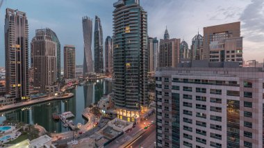 Dubai Marina yerleşim yerlerinin ve ofis gökdelenlerinin hava panoramik görüntüsü. Gün doğmadan önce gece gündüz geçiş zamanı. Yüzen tekneler ve yatlar