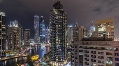 Dubai Marina yerleşim ve ofis gökdelenlerinin deniz kıyısına bakan zaman aralıklı görüntüsü. Yüzen tekneler ve yatlar