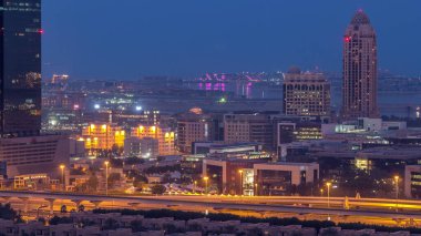 Dubai medya kenti, dubai, Birleşik Arap Emirlikleri, gündüz geçiş timelapse gökdelenler gece aydınlatılmış. Yolda trafik ile Yeşiller bölgesinden havadan görünüm