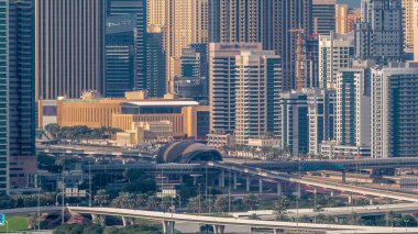 Dubai Marina ve golf sahası sabah timelapse, Dubai, Birleşik Arap Emirlikleri yakın crossroad ve metro istasyonu. Greens bölgesinden havadan görünüm. Yeşil çim ve trafik bir karayolu üzerinde
