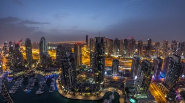 Dubai Marina gece gündüz geçiş timelapse havadan üst görünümü. Dubai, Bae gün doğumundan önce yüzen yatlar ve tekneler ile gezinti ve kanal. Işıklı modern kuleler ve yolda trafik