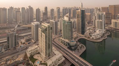 Dubai Marina ve Jlt sabah timelapse havadan üst görünümü. Dubai, Bae gün doğumundan sonra yüzen yatlar ve tekneler ile gezinti ve kanal. Modern kuleler ve yolda trafik
